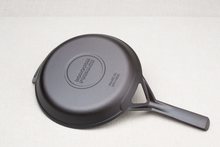 Load image into Gallery viewer, Underside of Borough Furnace 10.5-inch cast iron skillet showing stay cool helper handle and smooth finish